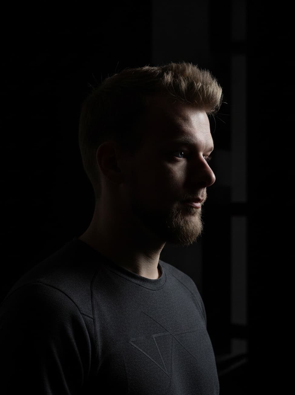Piotr Osmola, lit from the side in a dark gym
